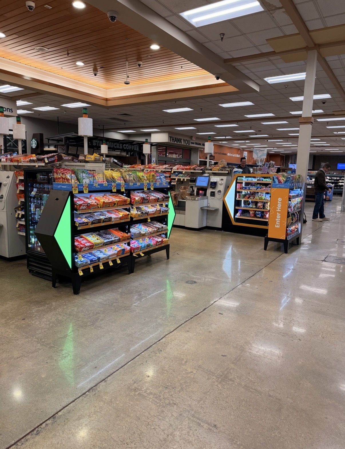Grocery transaction zone design with lit Arrow approach fixture directing shoppers to self-checkout